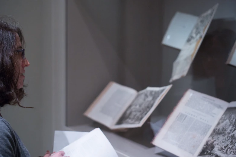 a lady with an open book looking at the pages