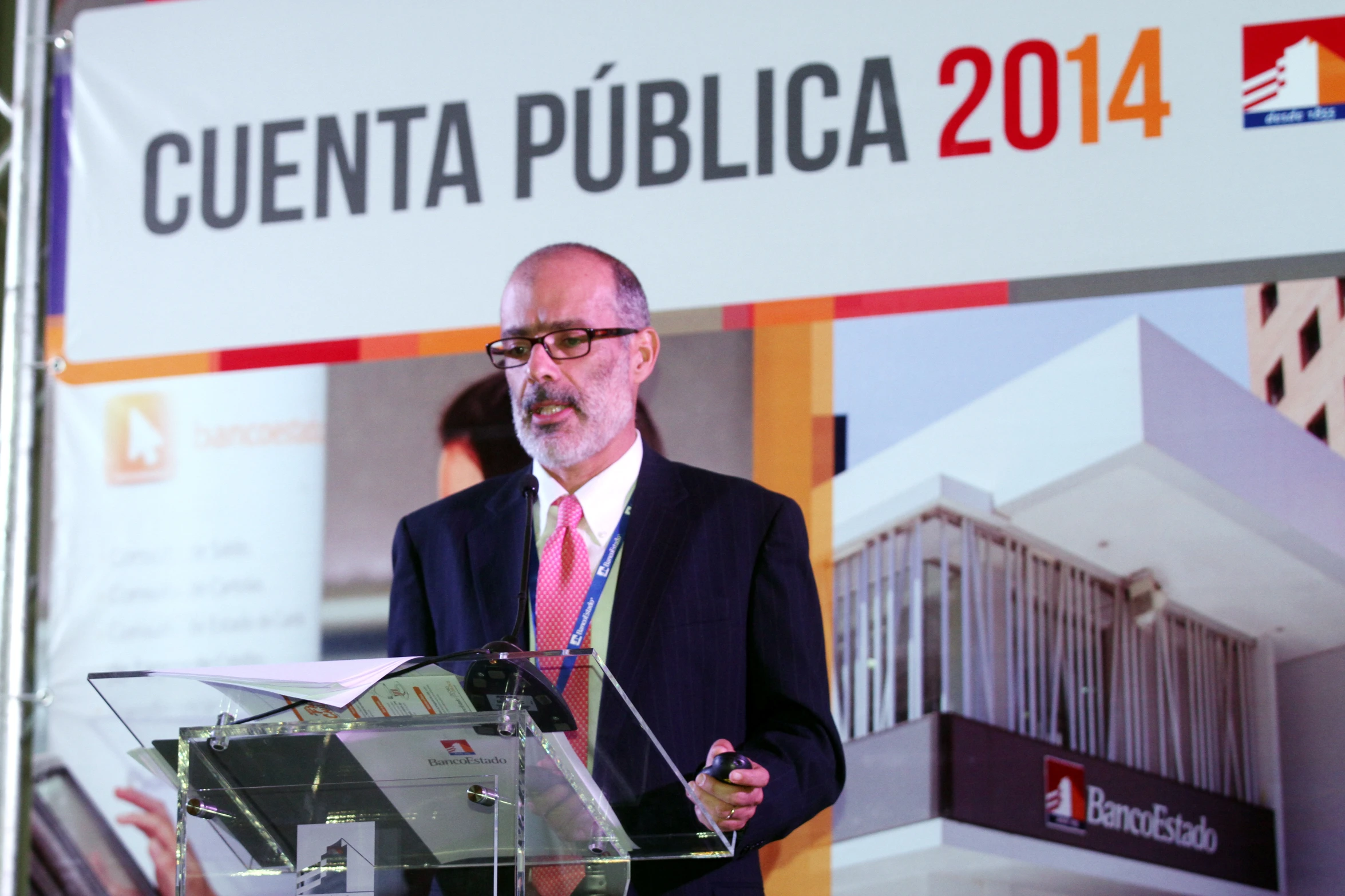 a man in business clothes standing behind a podium