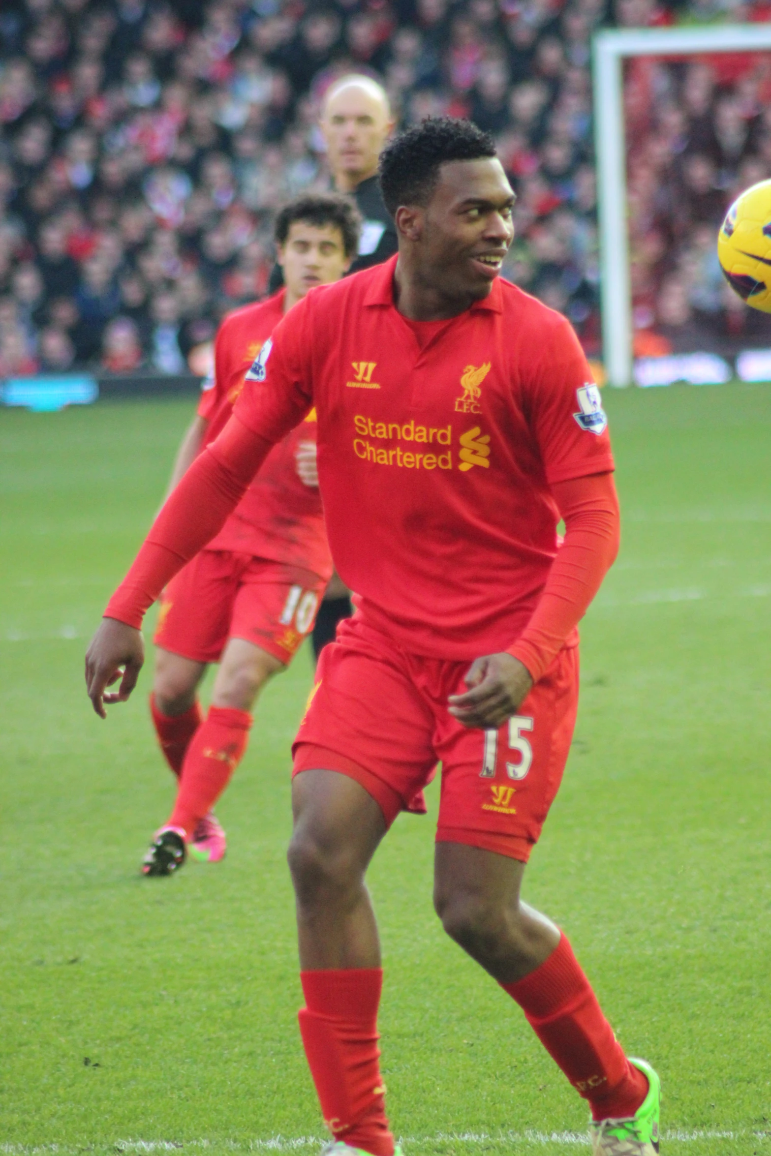 a soccer player looks on as the ball passes by