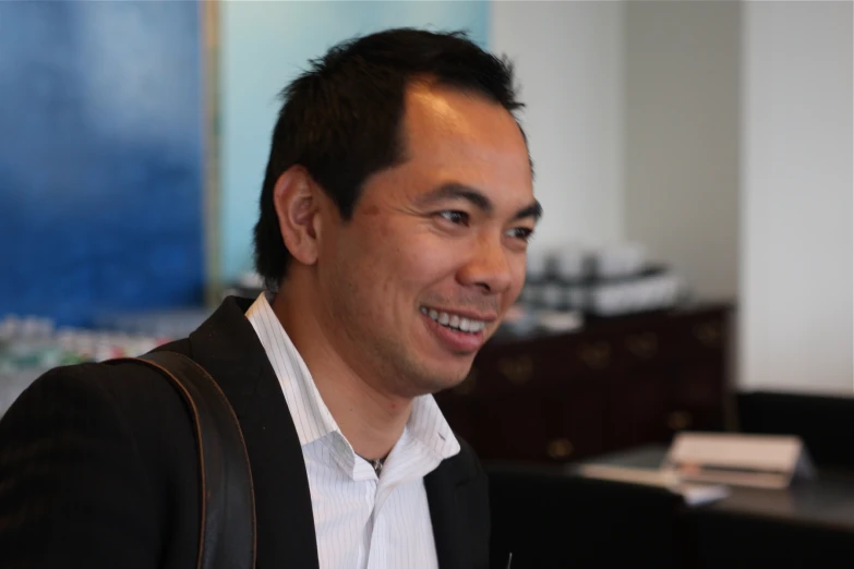 a man smiling in an office setting while looking around