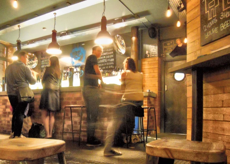 people are standing in the corner of a crowded bar