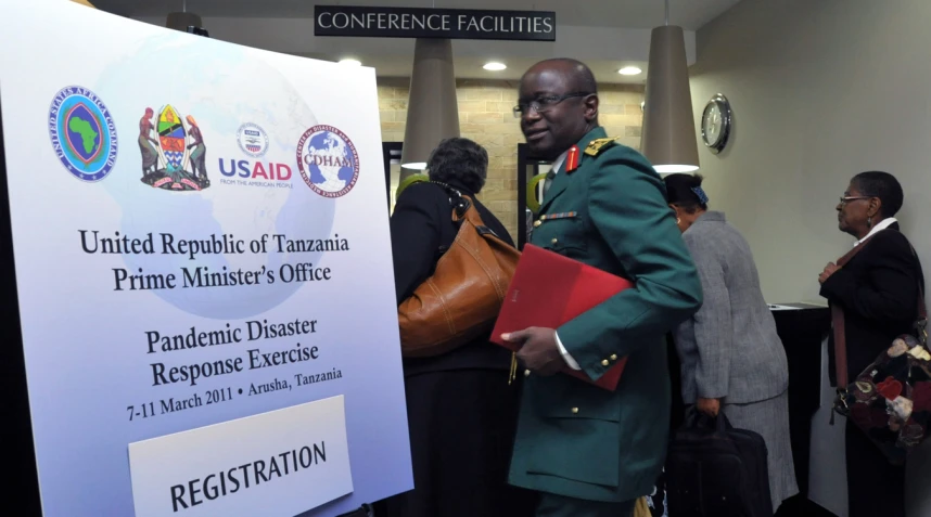 a soldier in a military uniform stands next to a board