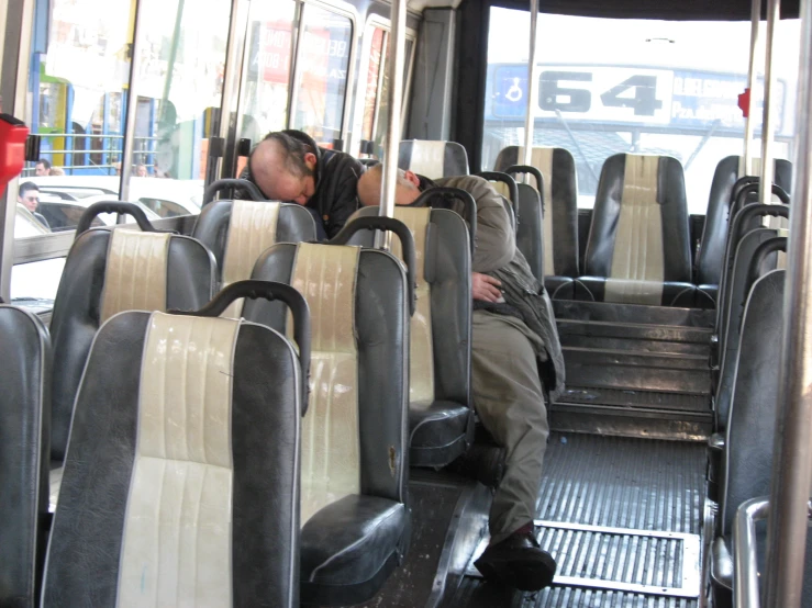 a man sitting on the side of a bus sleeping