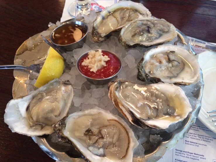 the oysters are served with dipping sauce and a side of lemon