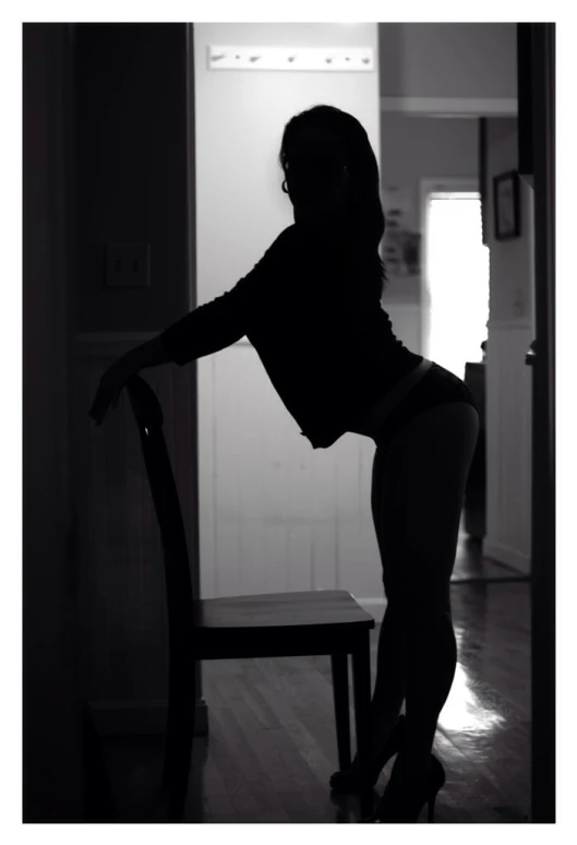 black and white image of woman in high heels sitting at table