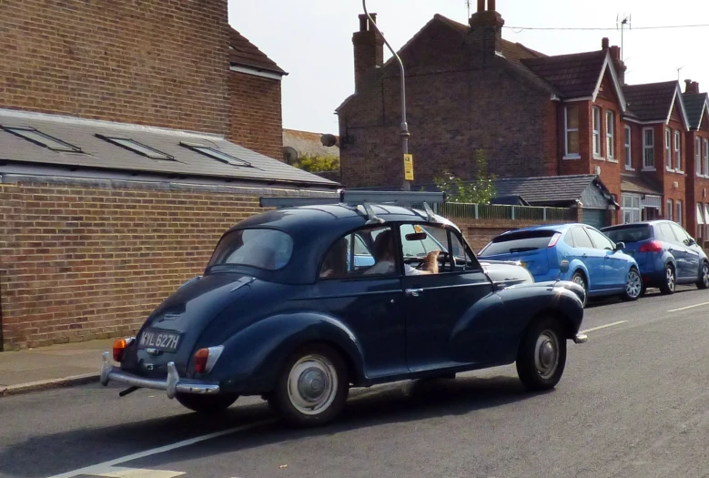 old cars line up on a residential street