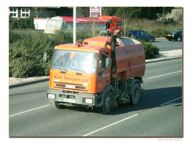 a large orange truck driving down the street
