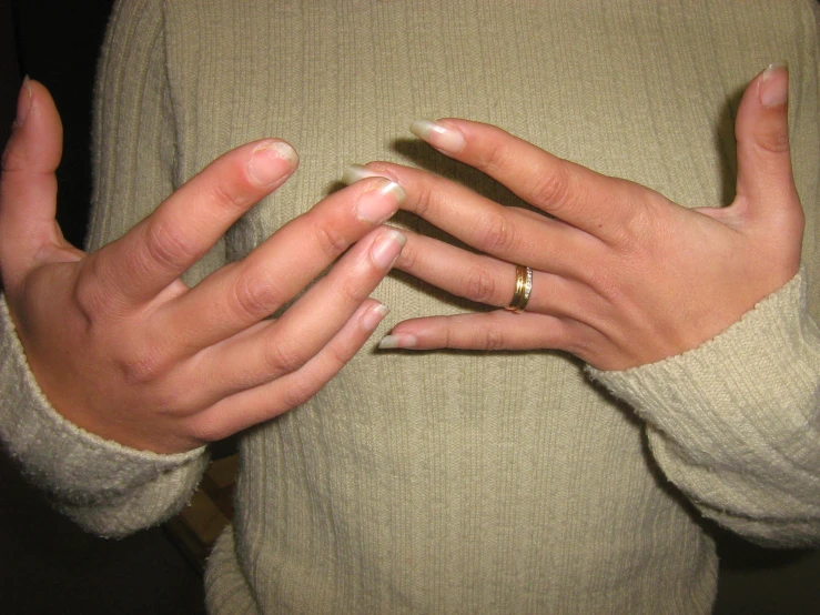 woman in sweater holding two rings around her torso