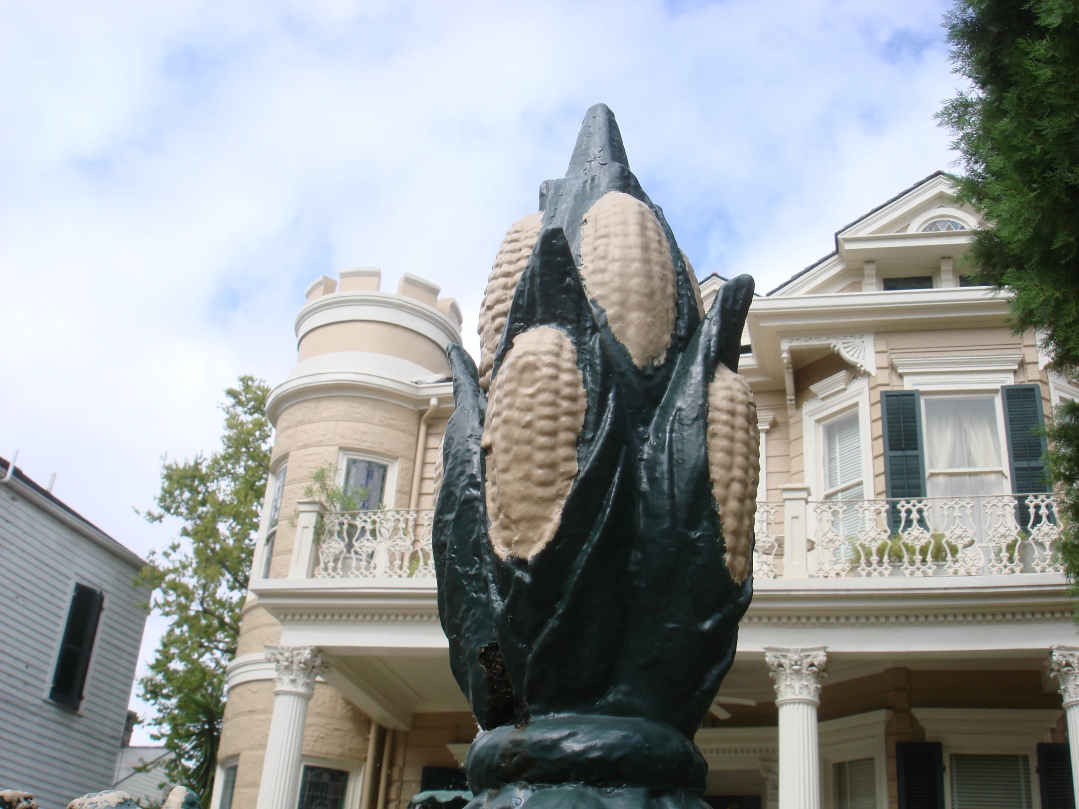 a sculpture sits in front of a big house