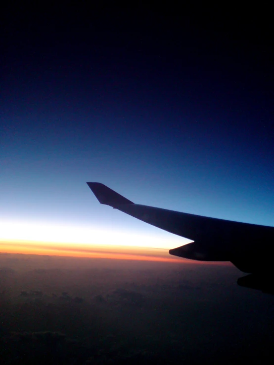 the view from an airplane window looking out at the sunset