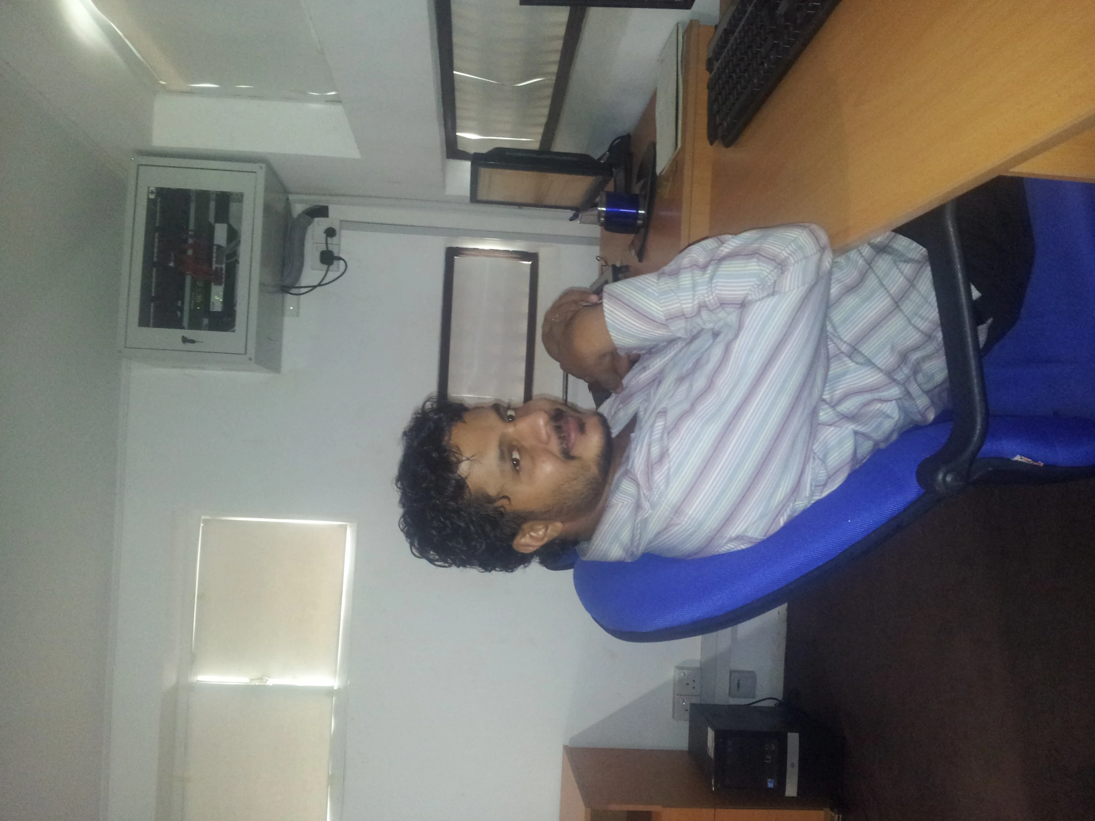 a man sitting at a desk with an empty monitor