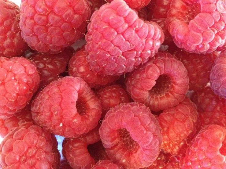 a bunch of raspberries are piled together
