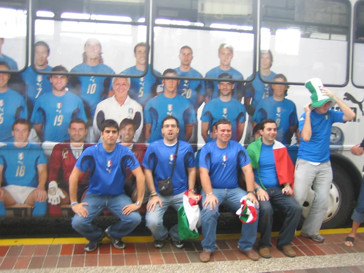 the men are posing for a picture in front of a bus