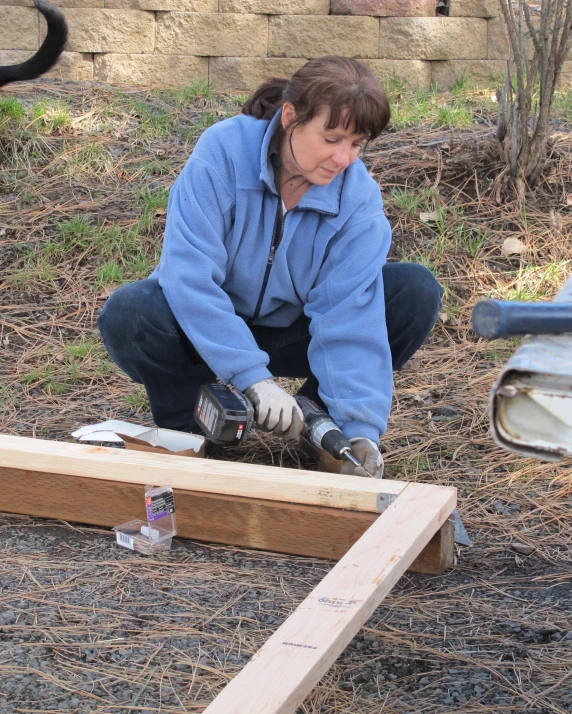 a woman using a pair of gloves on a wooden deck