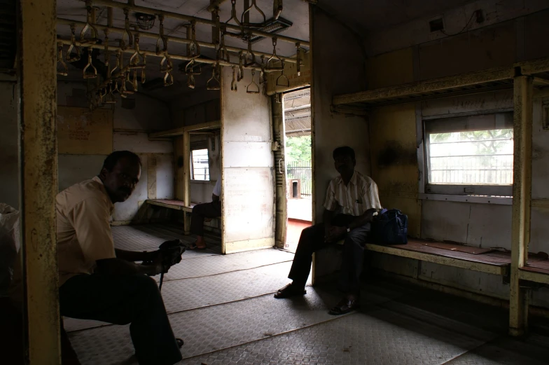 two men sitting on the floor in a small room