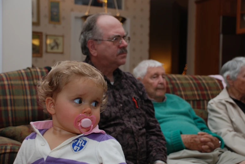 an elderly person and a child with pacifier