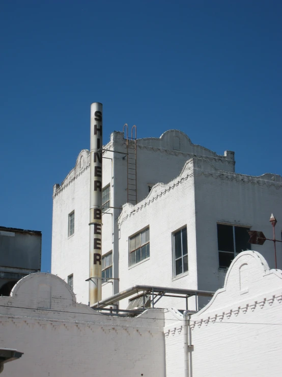 an industrial building with many windows and large sign