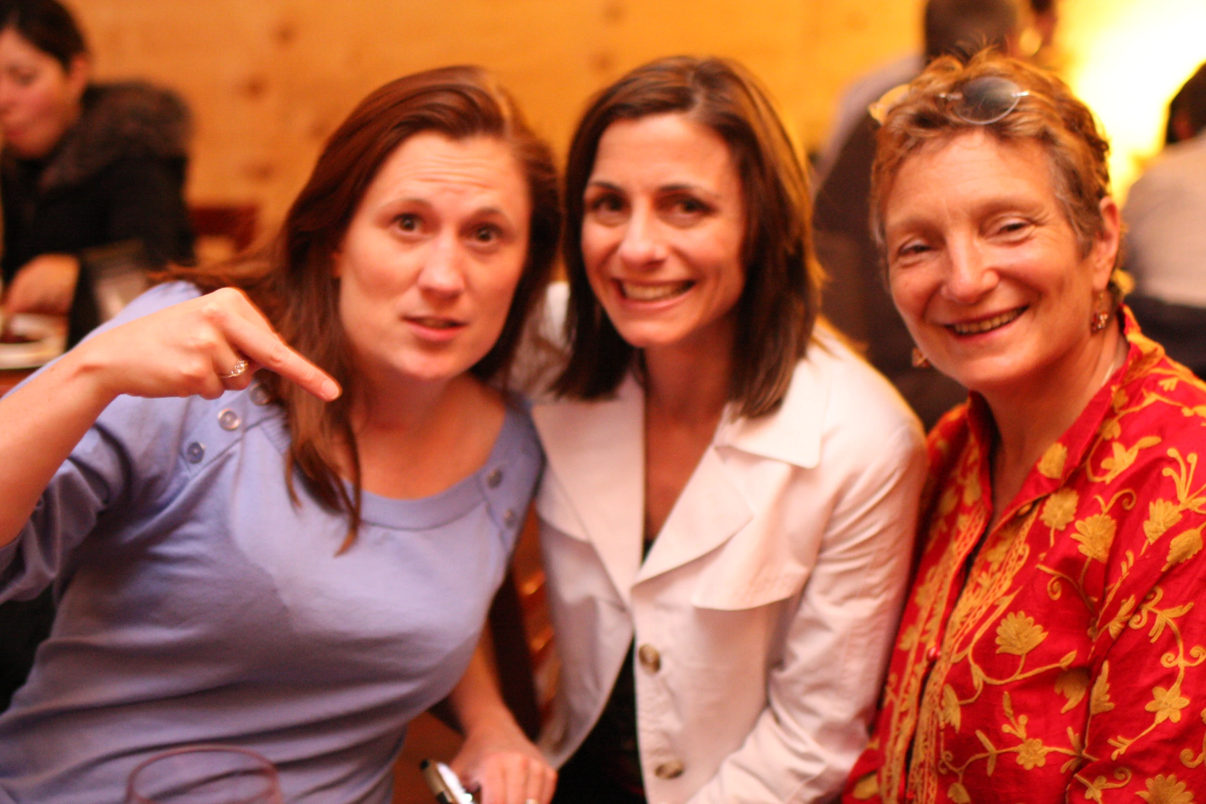 three women posing for the camera with wine