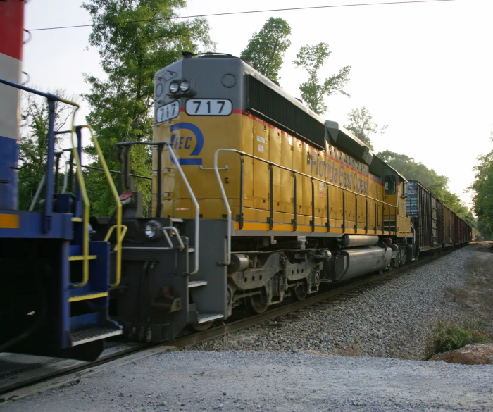 a yellow and blue train is pulling many cars