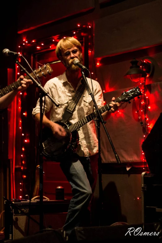 a person with long hair and a beard playing guitar