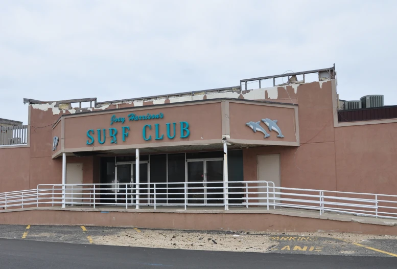 the outside of a restaurant that has blue birds on the sign and white railings