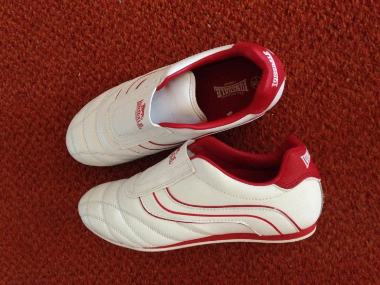 a red and white pair of shoes with the top sole painted red