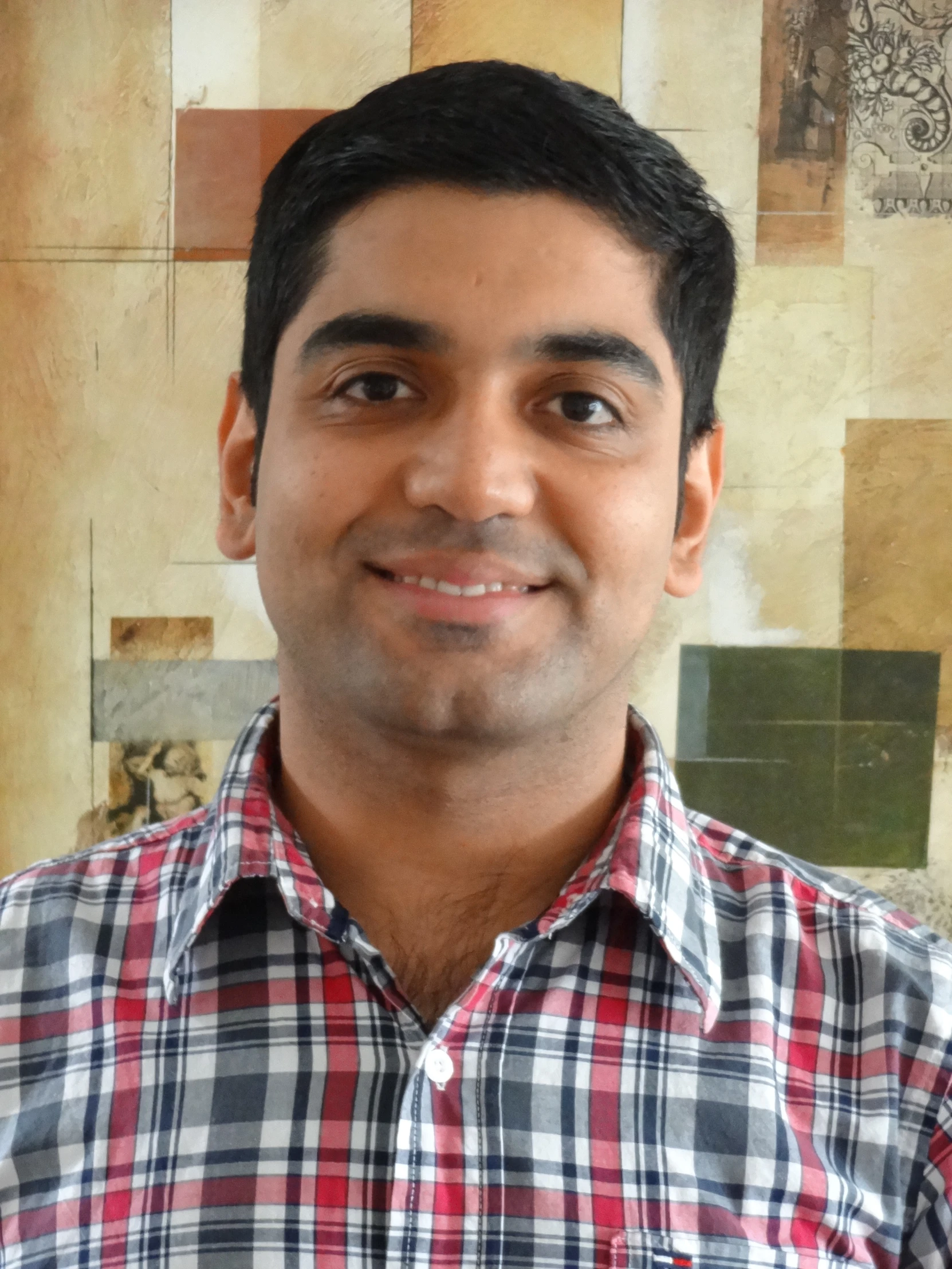 a man with black hair wearing a red and white shirt