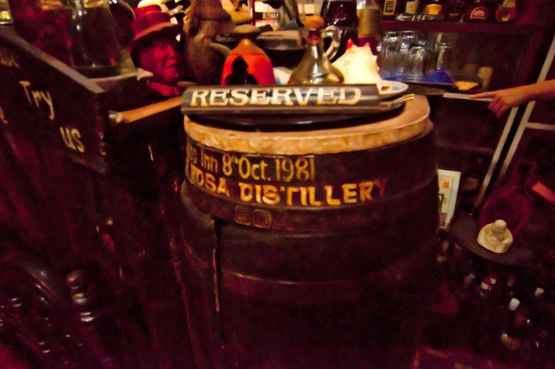 several barrels that are in front of bottles on the table