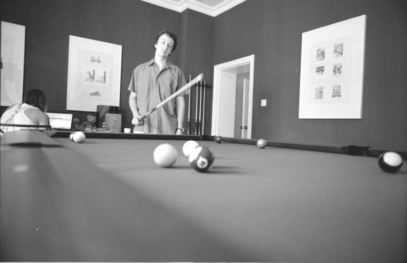 a man playing pool with his friends in black and white