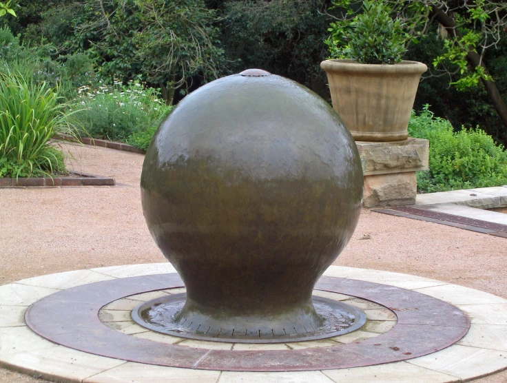 large metal vase sitting on the ground in a circle