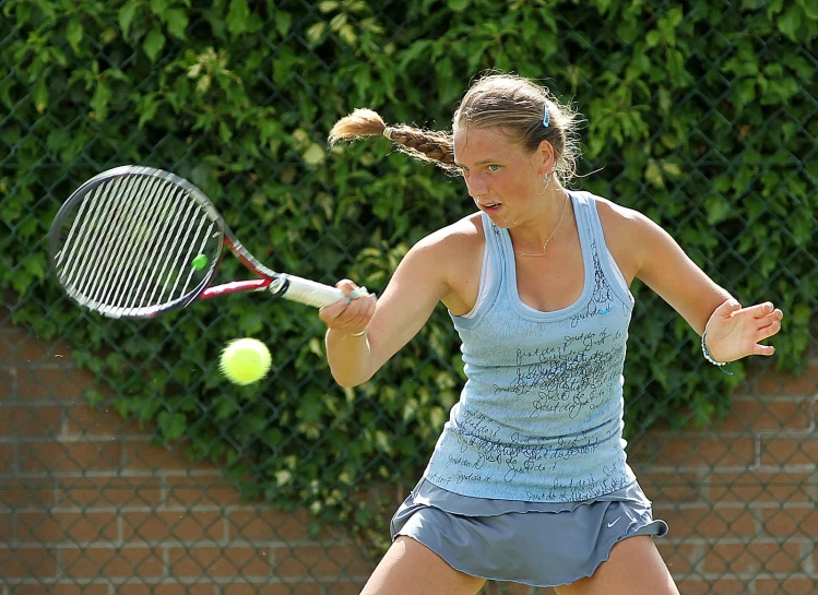 a woman hits a tennis ball on the court