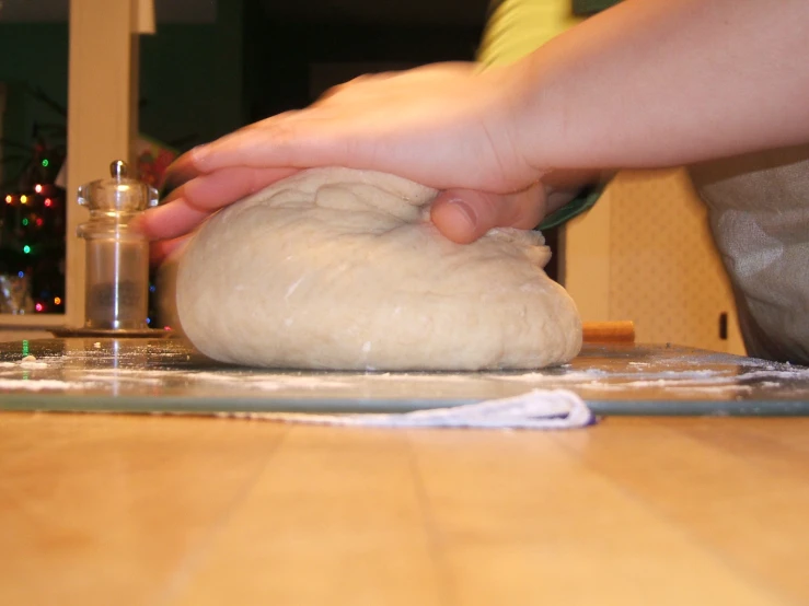 hands using bread dough in preparation for baking