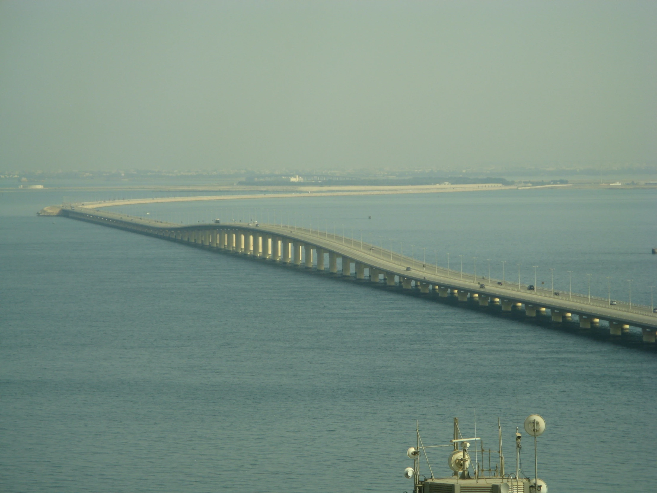 the large bridge is over looking the water and boats