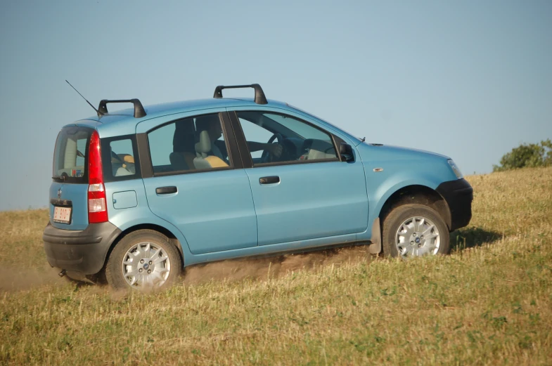 a blue vehicle in the middle of a grassy field