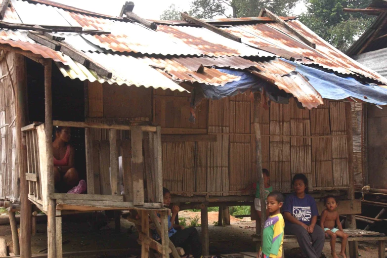 children sit on the roof of their small houses