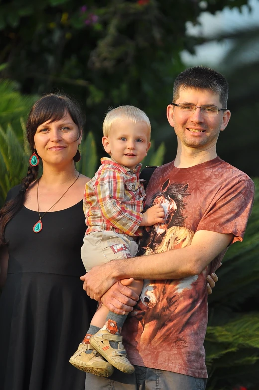 a man holding a child poses with his family