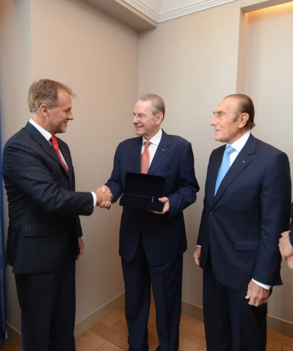 two men shaking hands with each other at a meeting