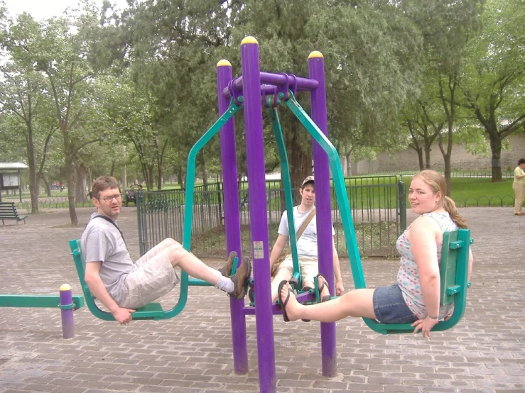 a couple of people sitting next to each other on a purple play structure