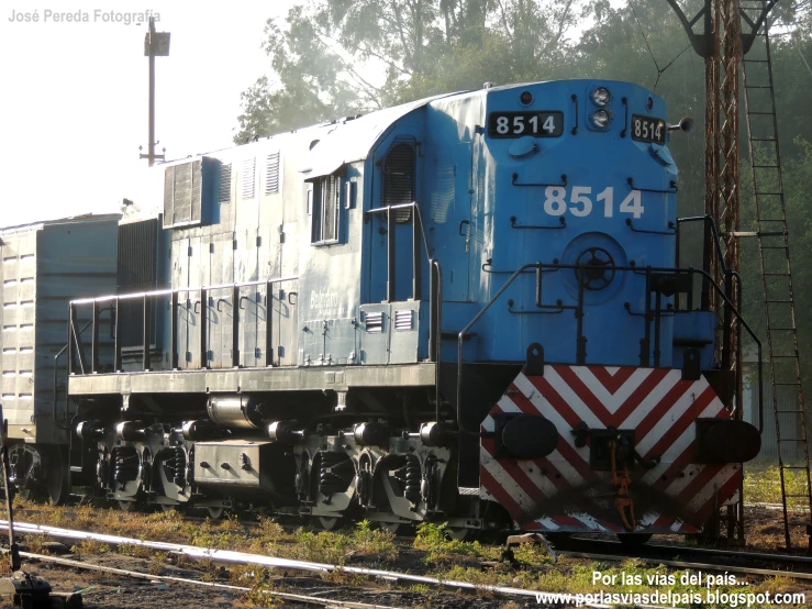 a blue train that is sitting on the tracks