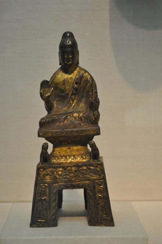 a gold sculpture of a buddha inside a room