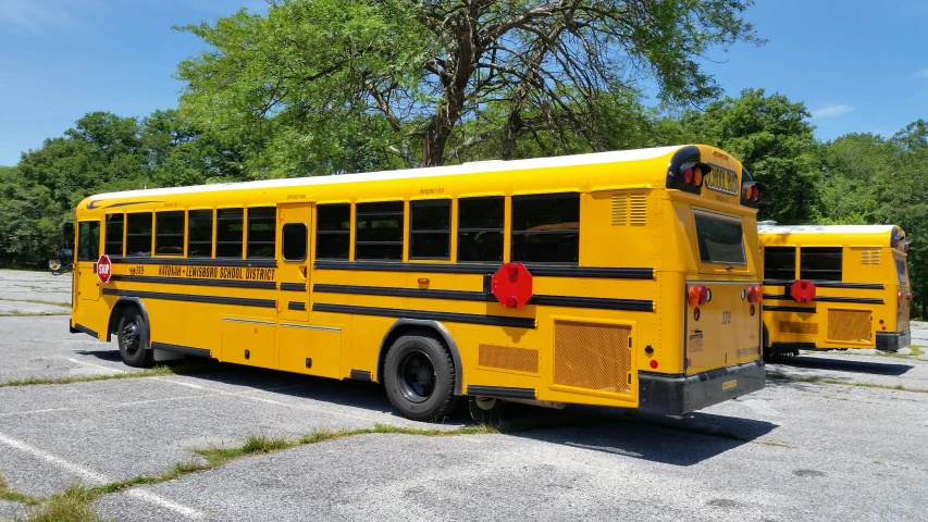 two empty yellow school buses are parked next to each other