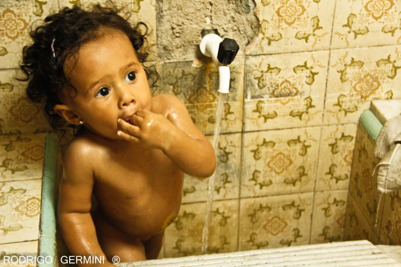 a child in a tub brushing it's teeth