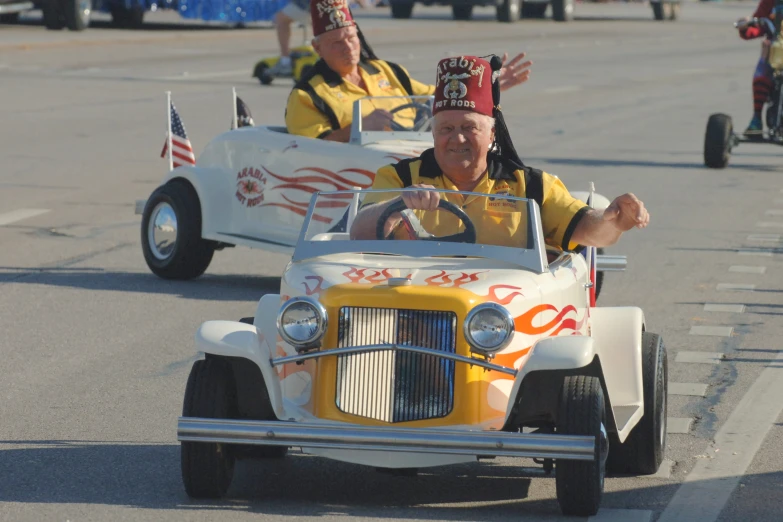 some people in a car driving on street with one holding a sign