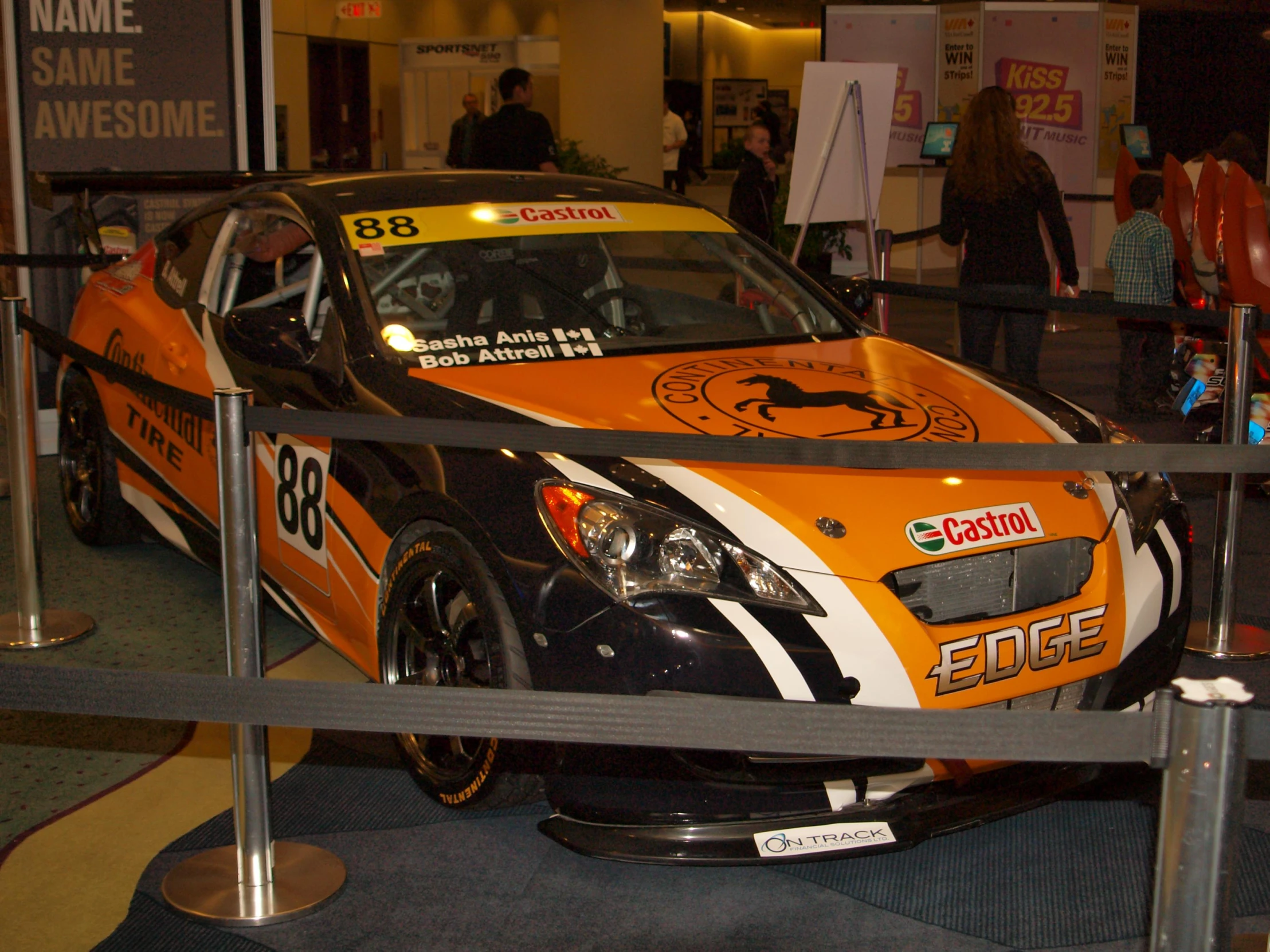 a black and orange racing car is on display in the mall