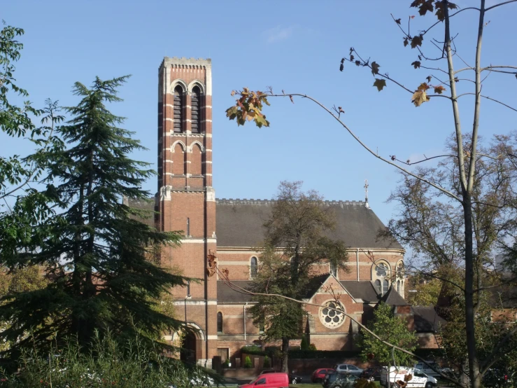 an older church sits next to trees and a field