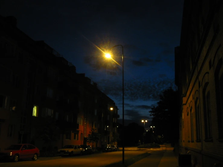 the street light shines brightly as dark as the building next to it