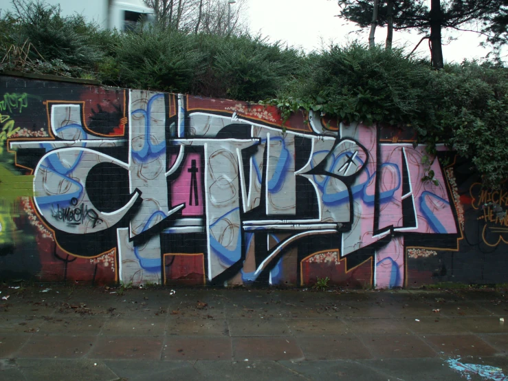 the graffiti painted on the wall is depicting three letters