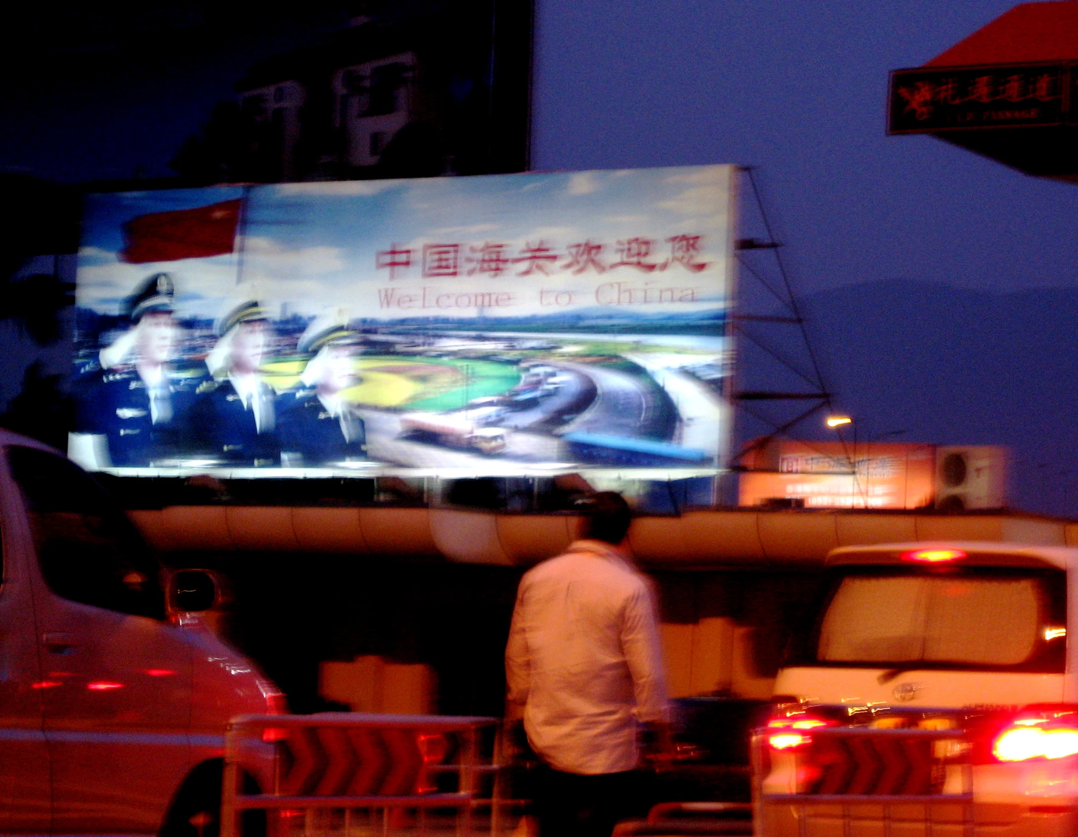 a man standing in front of a billboard at night