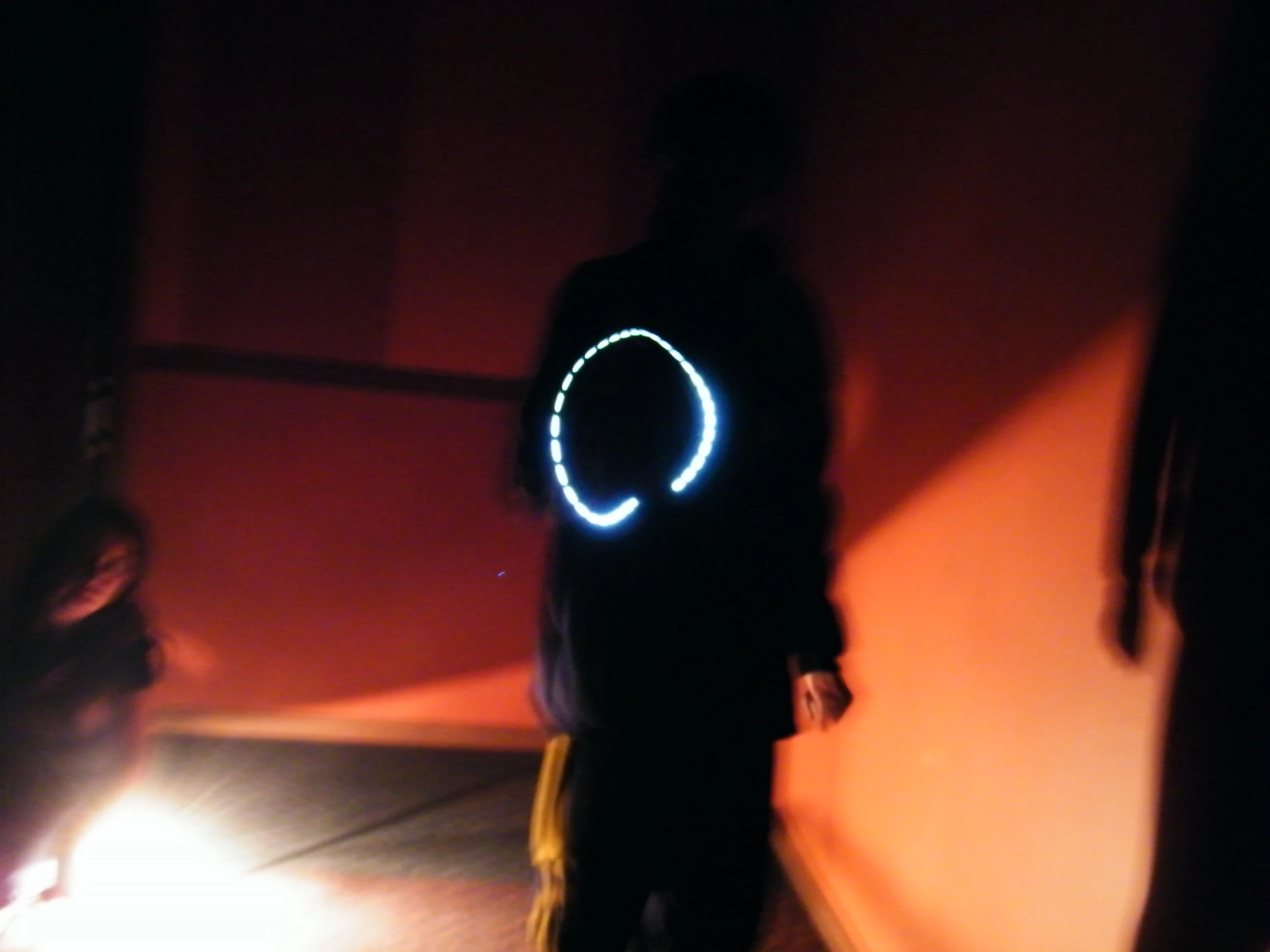 a person is walking with a glow ring on their back