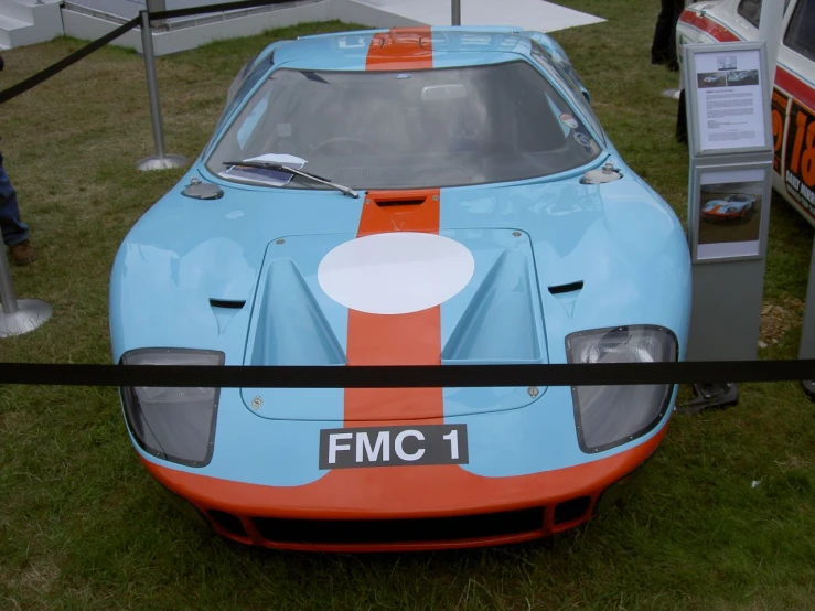 a very nice looking blue car parked near some people